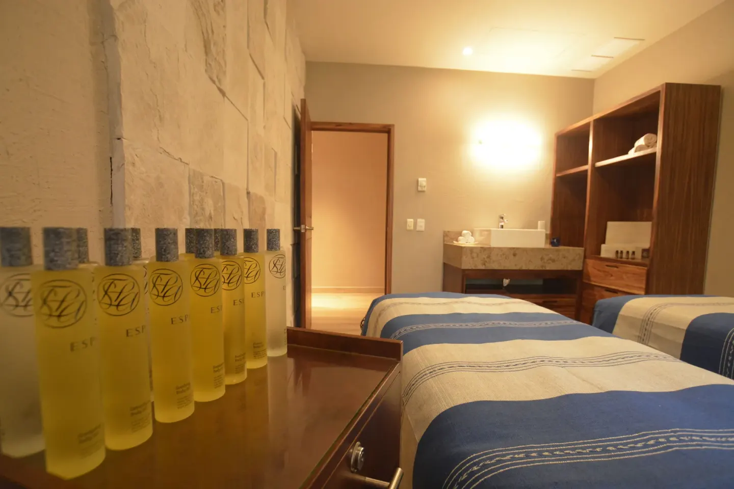 Spa treatment room with two massage beds and bottles of oil at Las Brisas Ixtapa.