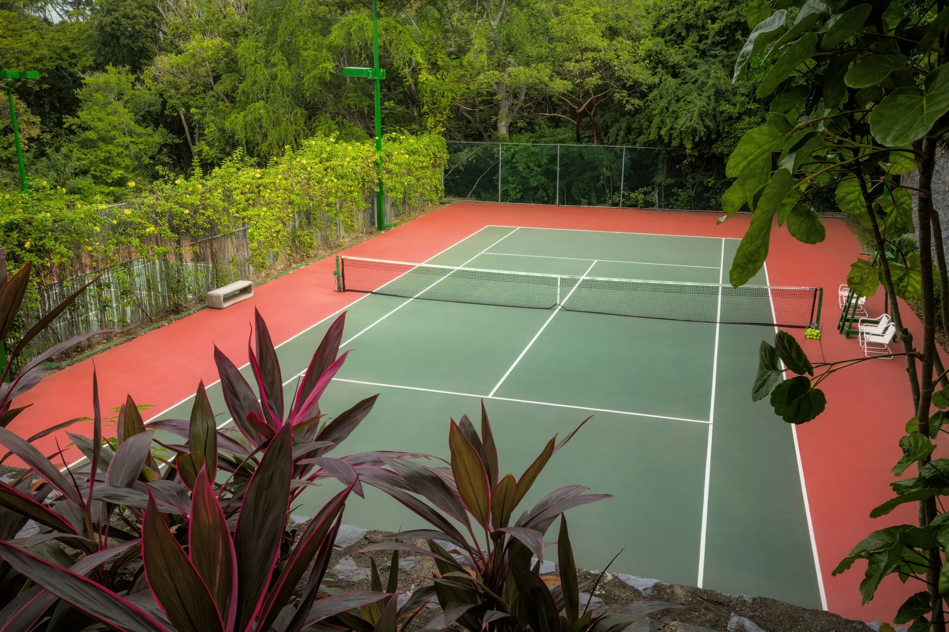 Green and red tennis court surrounded by tropical trees at Las Brisas Ixtapa.