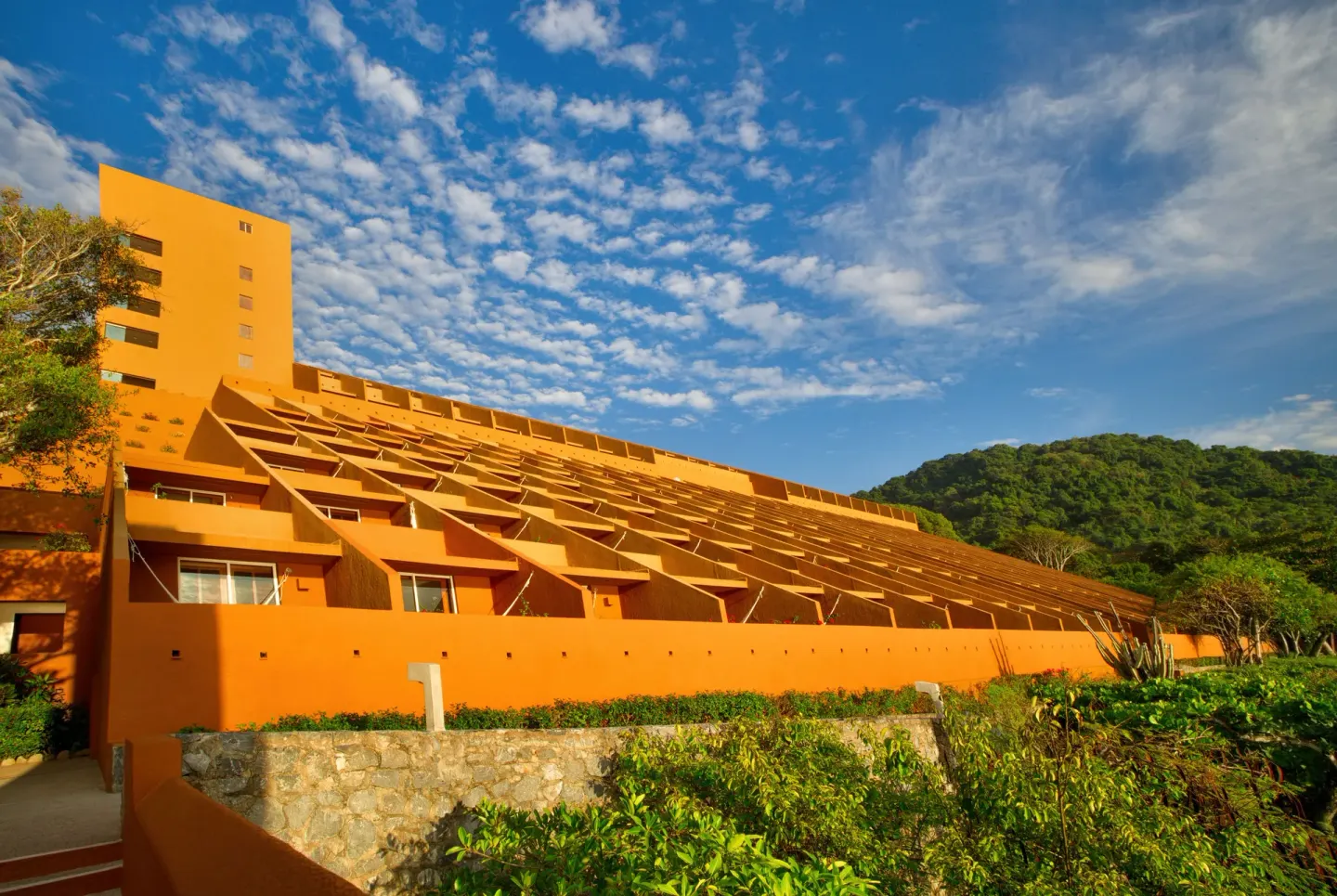 Terraced orange resort buildings rise beside green hills at Las Brisas Ixtapa.