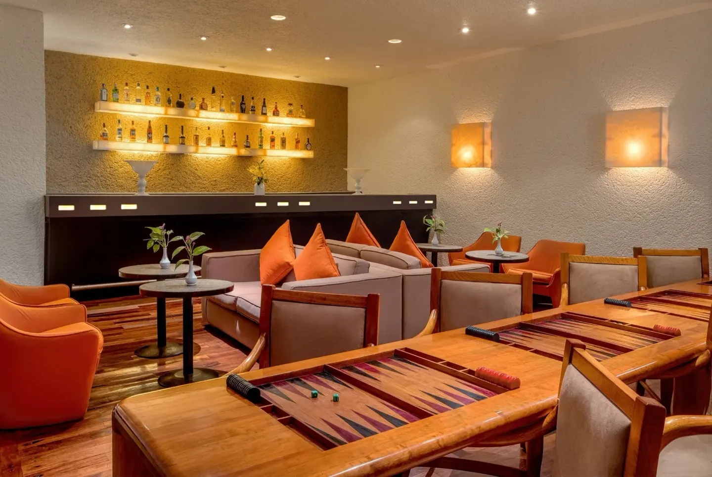 Lounge bar with bottle display, sofas, and backgammon tables at Las Brisas Ixtapa.