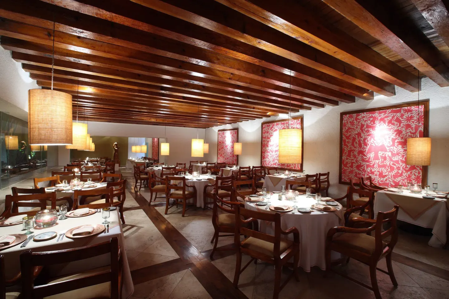 Restaurant dining room with wood beams and red wall panels at Las Brisas Ixtapa.