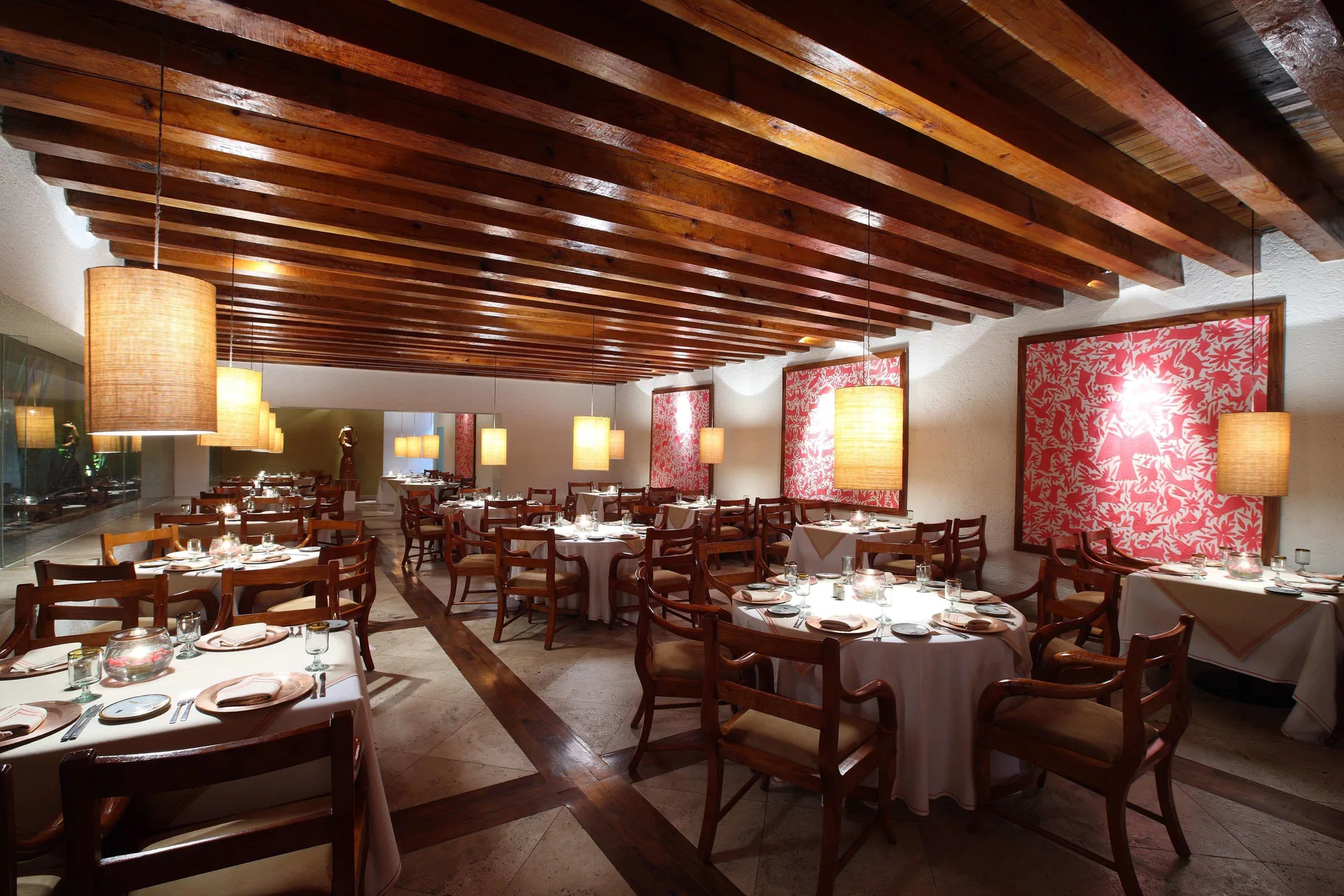 Restaurant dining room with wood beams and red wall panels at Las Brisas Ixtapa.