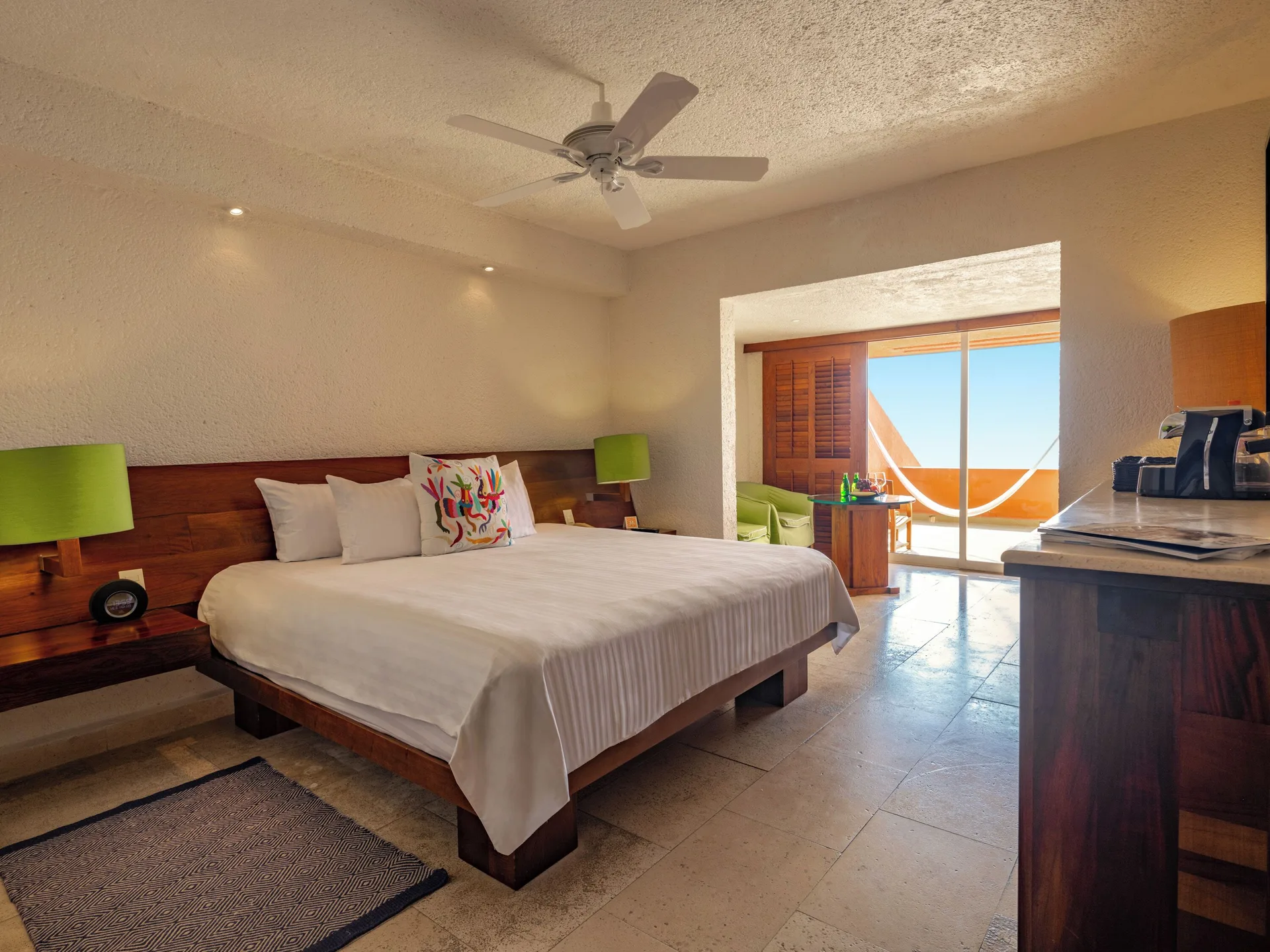 Deluxe Grand Bed guest room at Las Brisas Ixtapa with king bed, ceiling fan, desk, and balcony light.