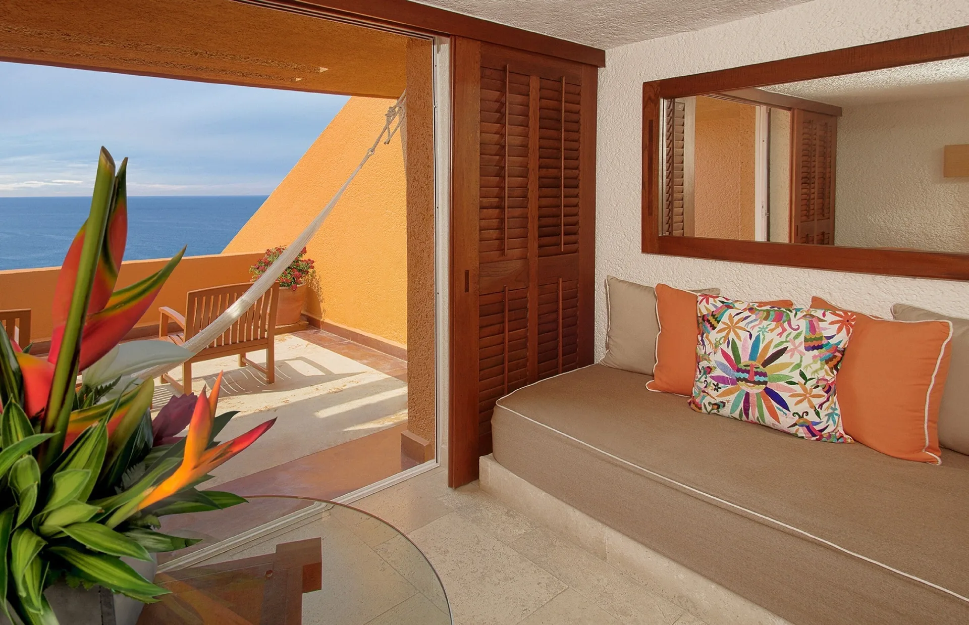 Deluxe Grand Bed sitting area at Las Brisas Ixtapa with daybed, balcony hammock, and ocean view.