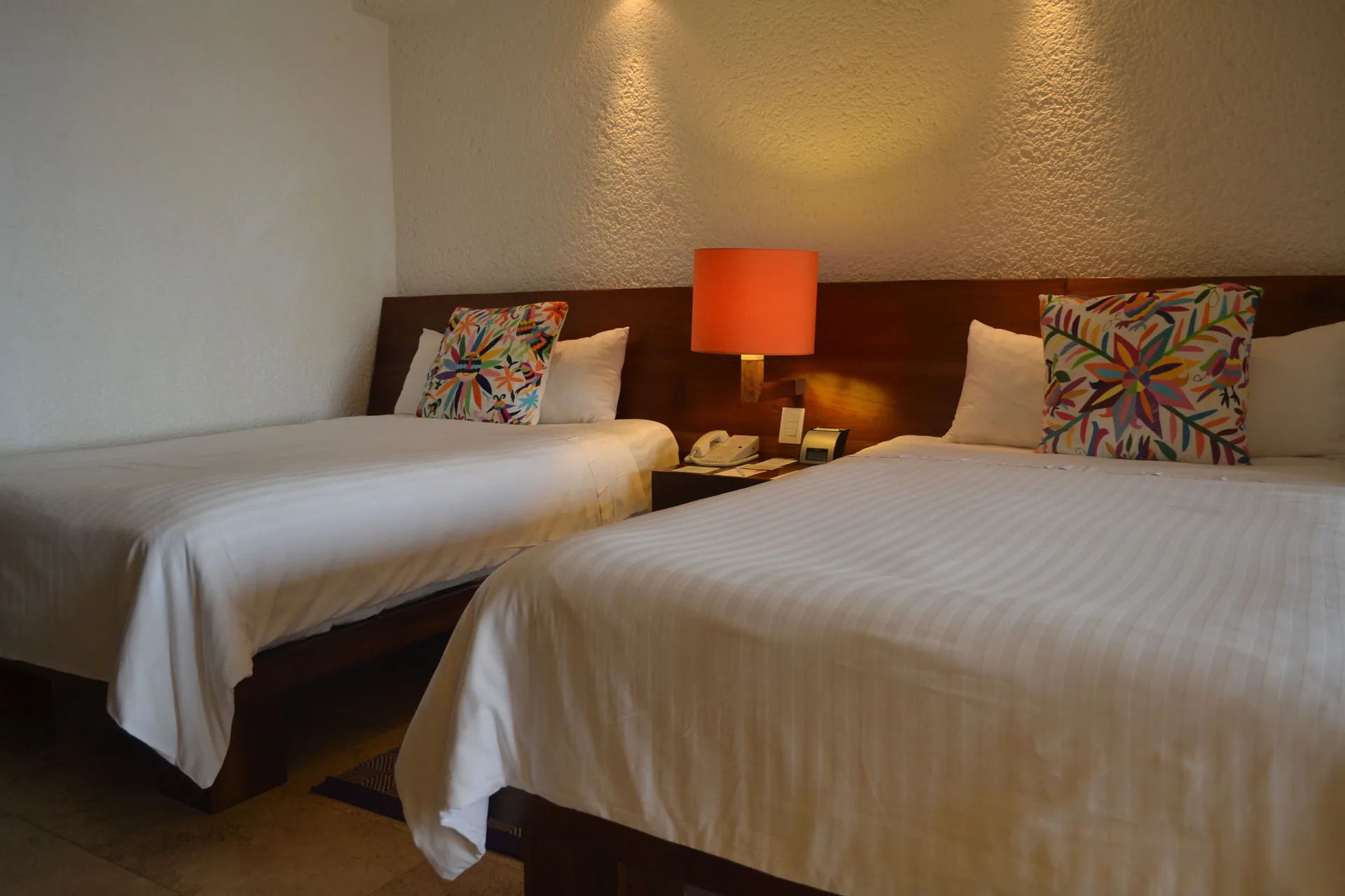 Deluxe Grand room with two beds and orange bedside lamp at Las Brisas Ixtapa.