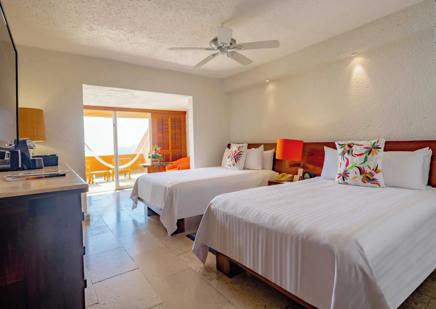 Deluxe Grand room with two beds and bright balcony doorway at Las Brisas Ixtapa.