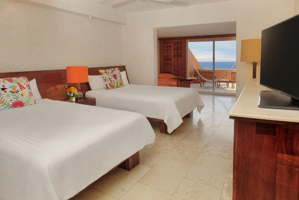 Deluxe Grand room with two beds, balcony, and ocean view at Las Brisas Ixtapa.