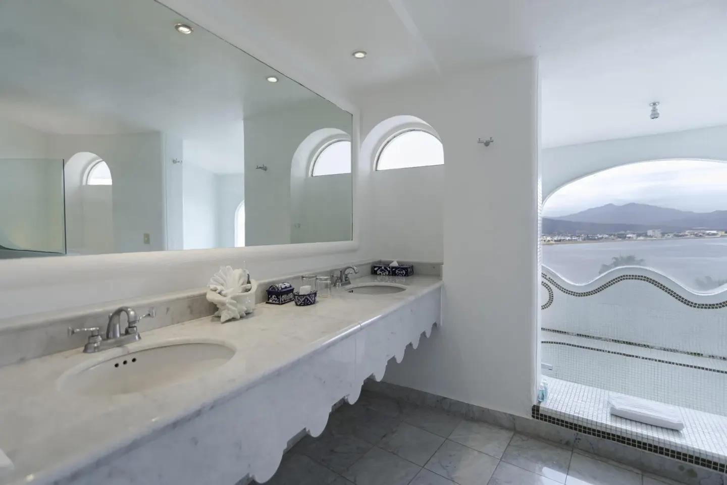 Marble double vanity and open shower with bay view at Las Hadas.