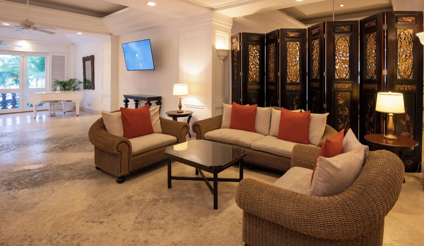 Lobby sitting nook at Las Hadas with wicker furniture and a carved folding screen.