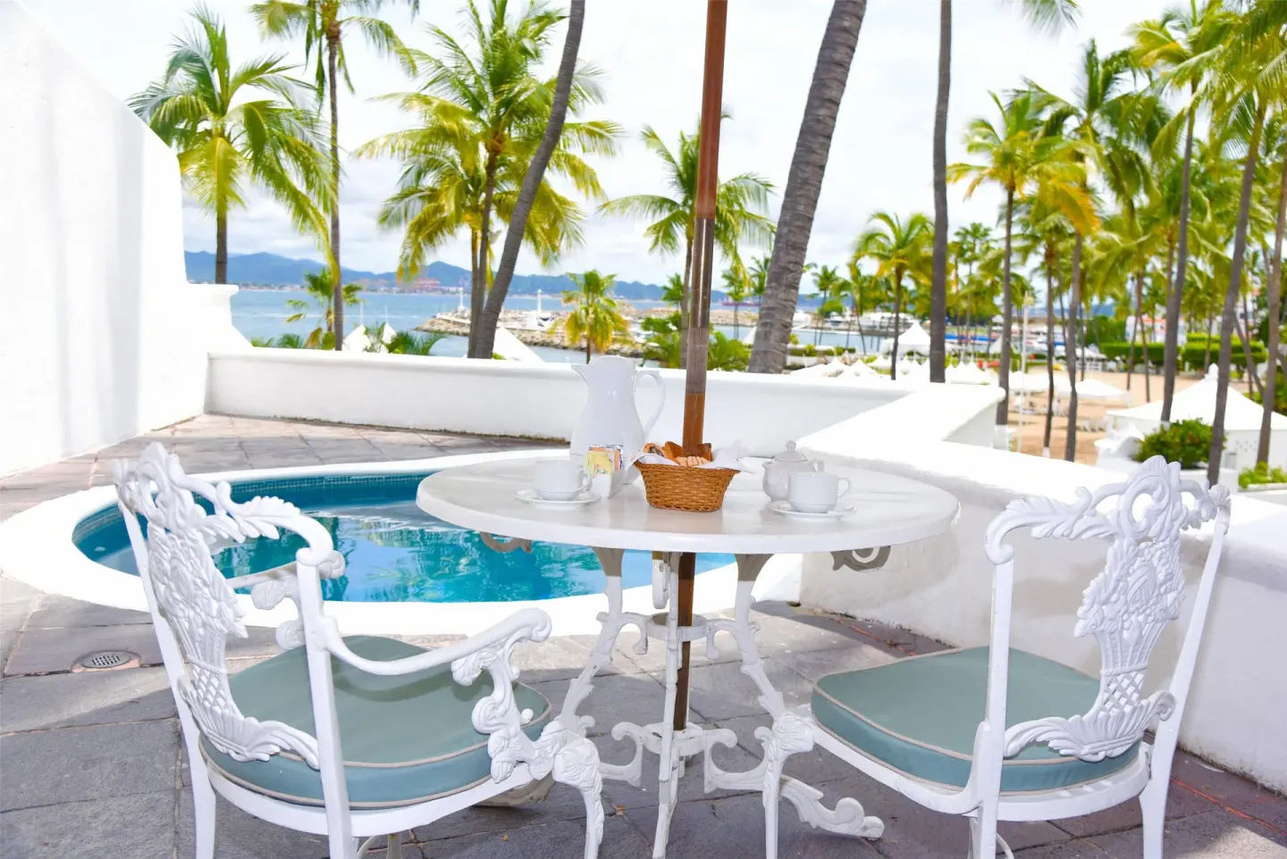 Private terrace with plunge pool, table, palms, and bay view at Las Hadas.