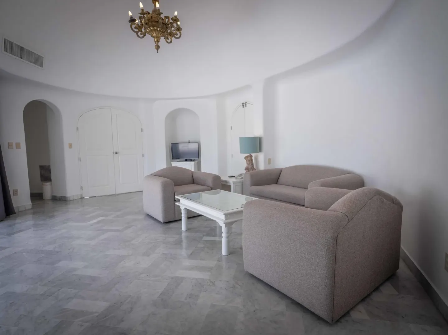 Living room suite area with sofa, armchairs, and chandelier at Las Hadas.