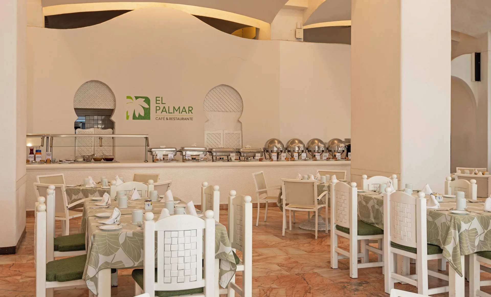 El Palmar dining room with set tables and a buffet counter at Las Hadas.
