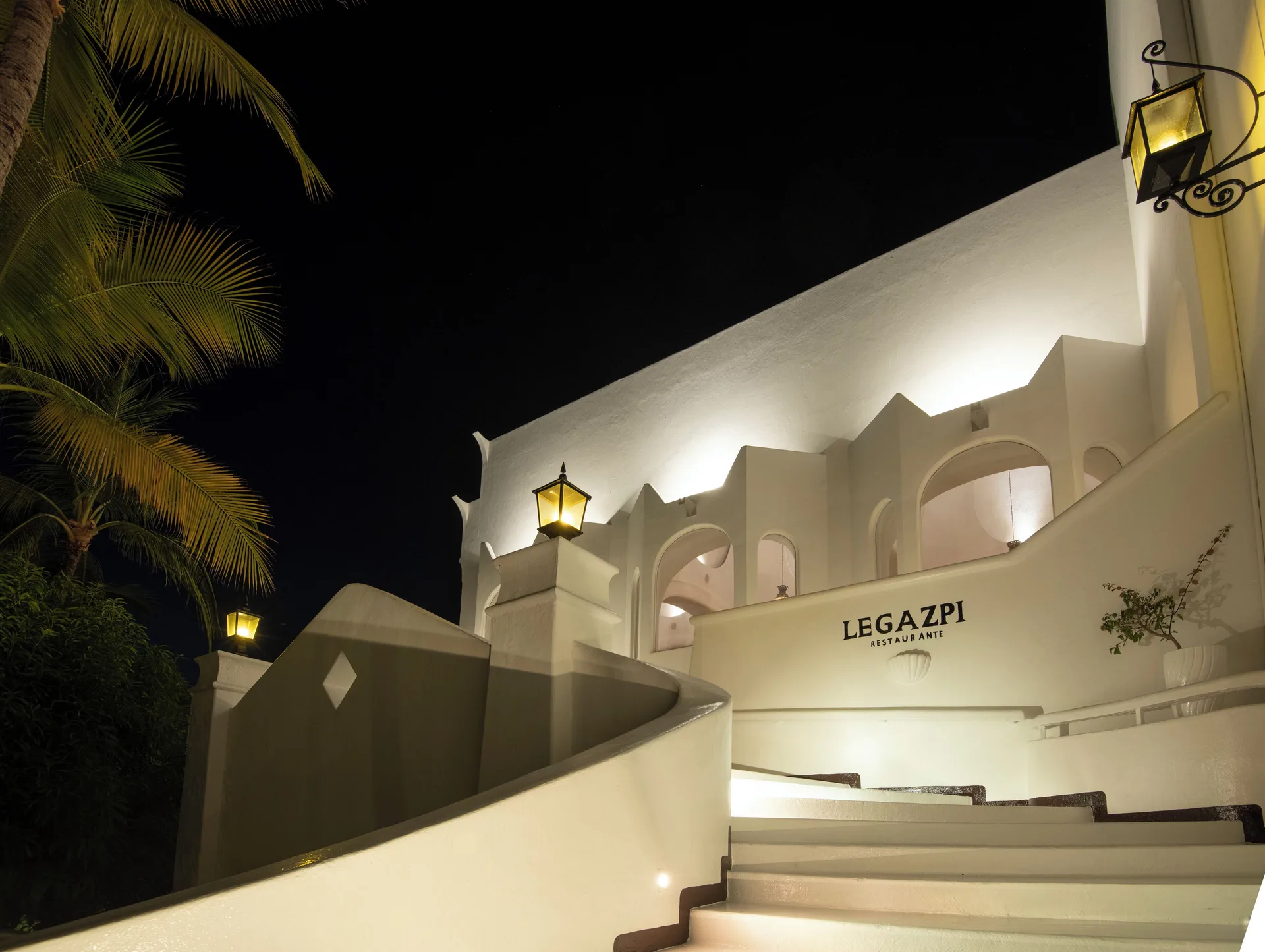 Nighttime exterior stairs and sign for Legazpi restaurant at Las Hadas.