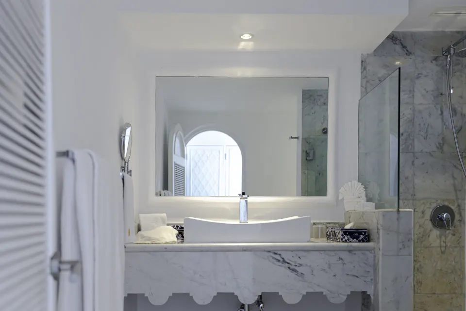 Deluxe Room bathroom vanity and shower with marble tile at Las Hadas.