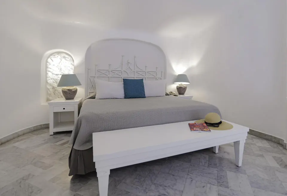 Fantasy Suite king bed with white bench and bedside lamps at Las Hadas.