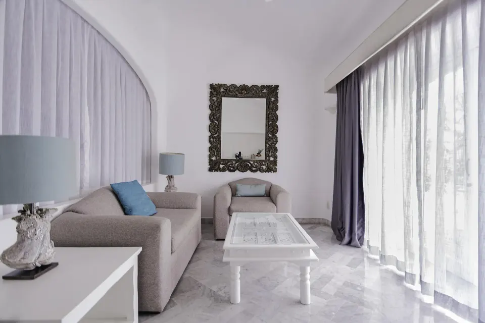 Fantasy Suite living area with sofa, armchair and sheer curtains at Las Hadas.