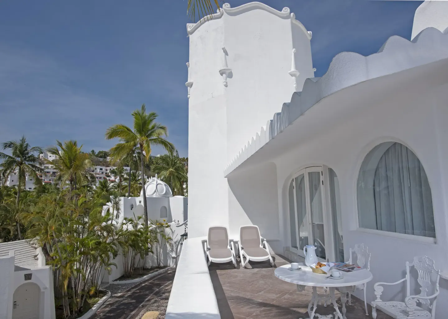 Fantasy Suite terrace with loungers, table and white architecture at Las Hadas.