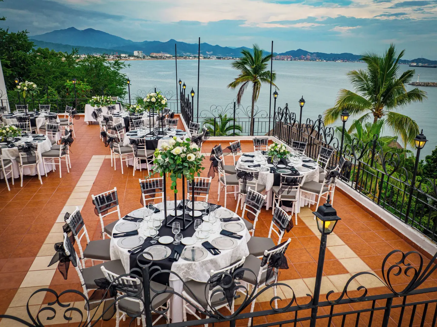 Outdoor event terrace with round tables overlooking the bay at Las Hadas.