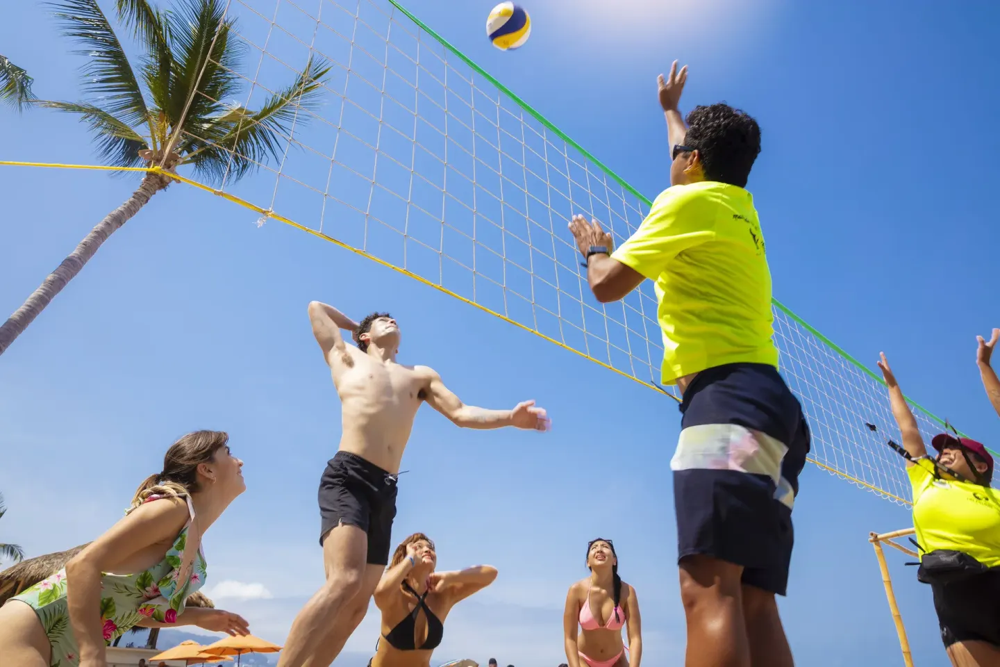 Beach volleyball players jumping near the net at Las Palmas by the Sea.