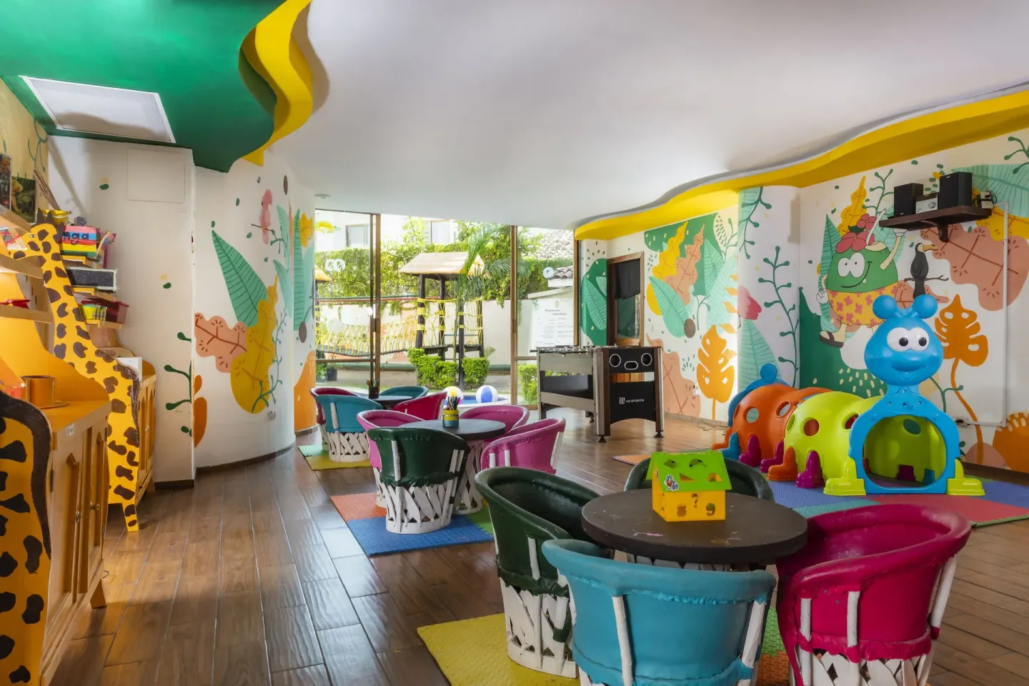 Colorful kids club with tables, murals, and play structures at Las Palmas by the Sea.