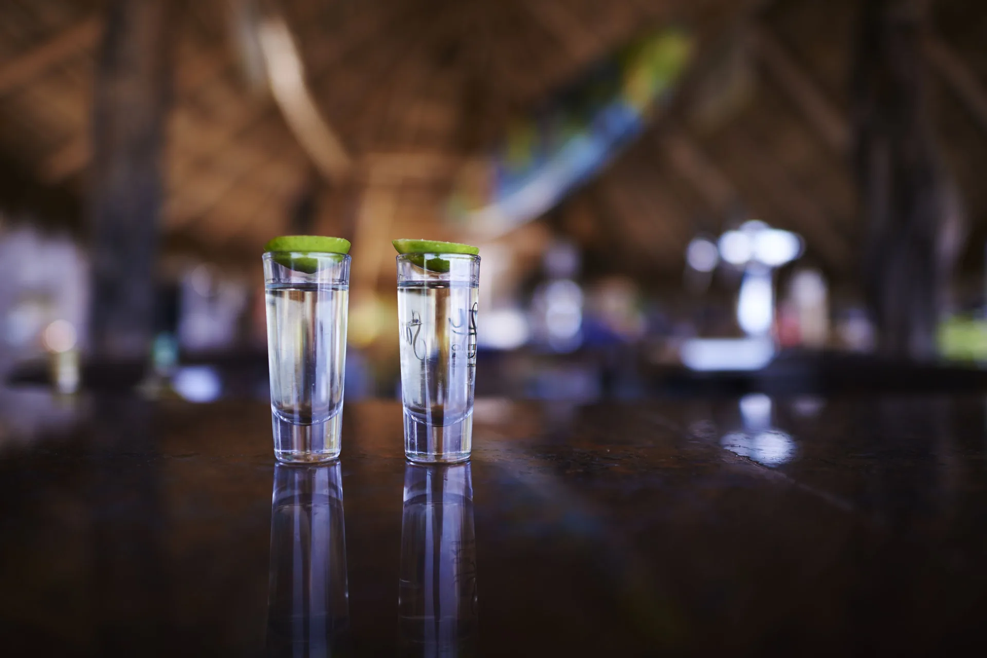 Two clear drinks with lime on a dark bar counter at Las Palmas by the Sea.