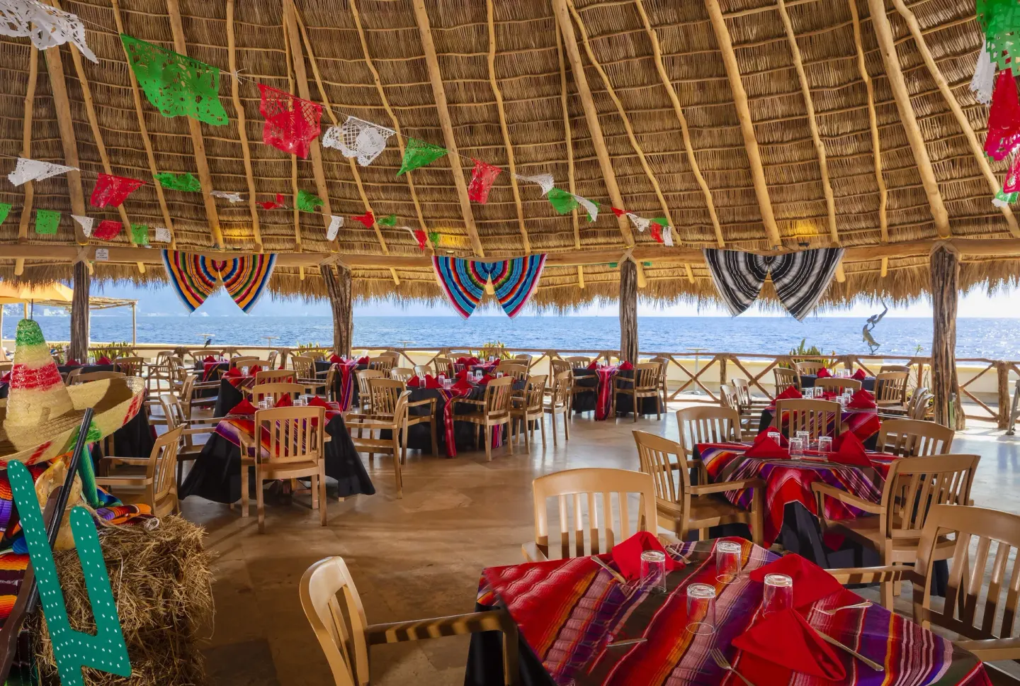 Open-air palapa dining room with ocean views and festive table decor at Las Palmas by the Sea.