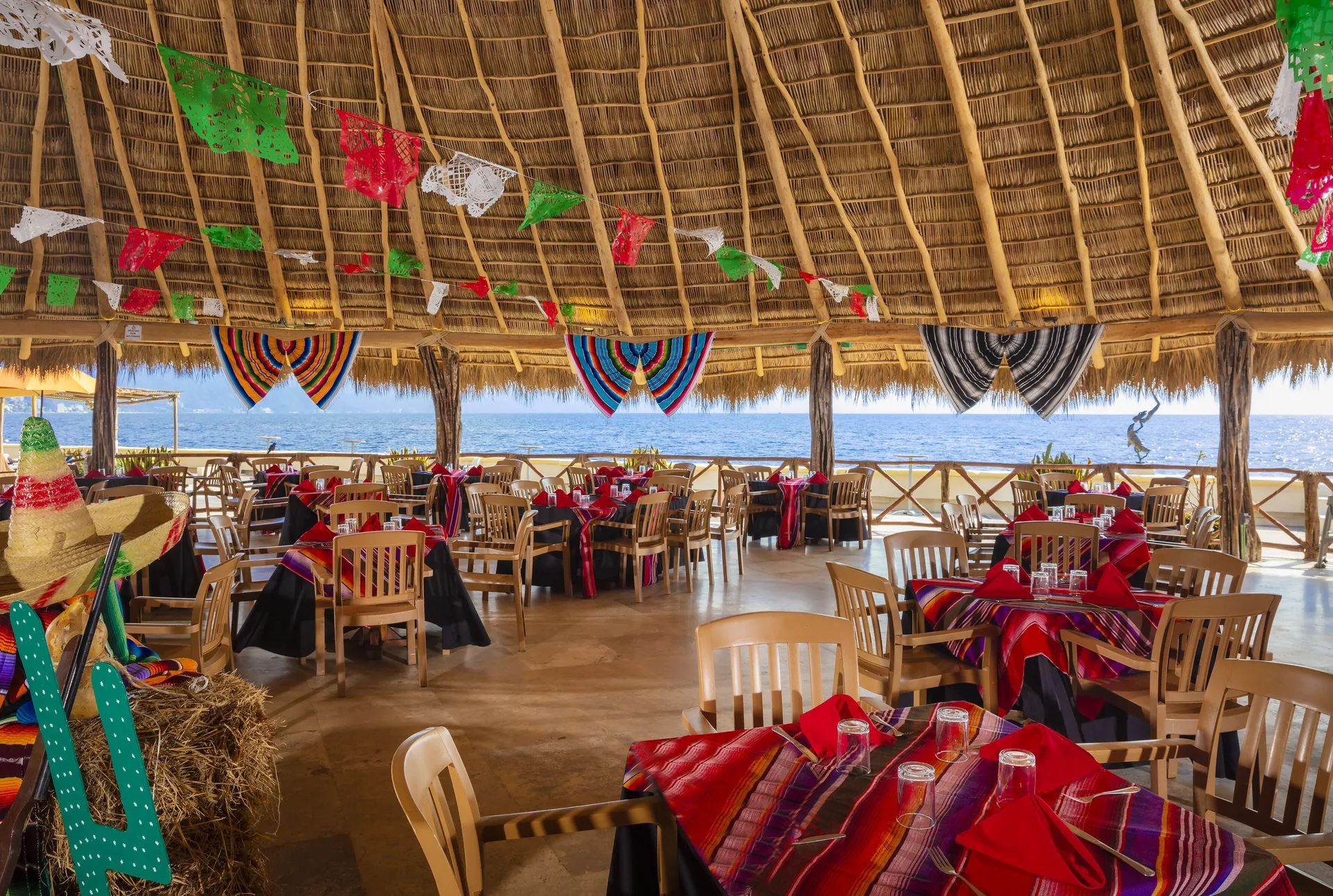 Open-air palapa dining room with ocean views and festive table decor at Las Palmas by the Sea.