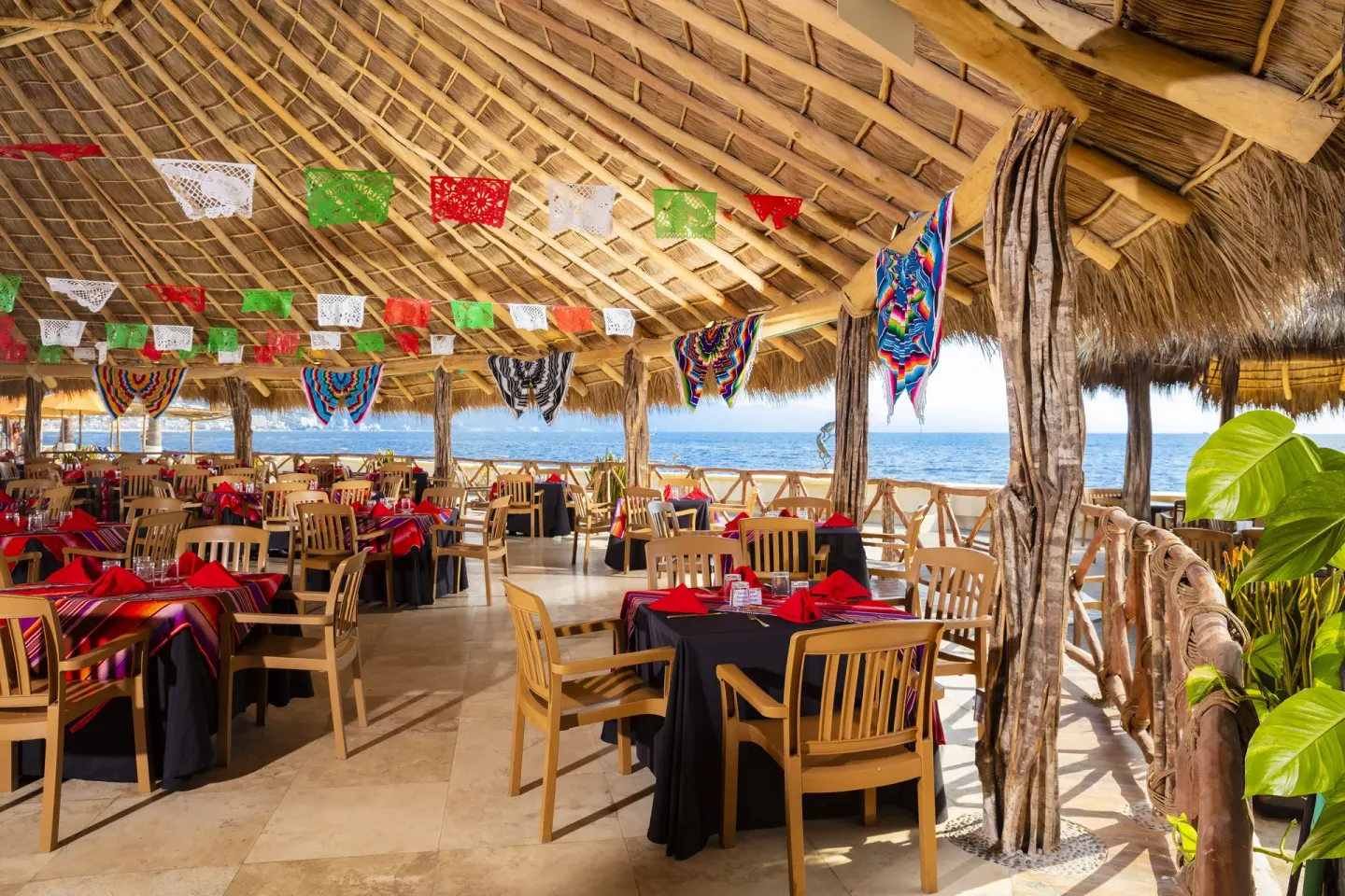 Palapa restaurant with colorful decorations and ocean views at Las Palmas by the Sea.