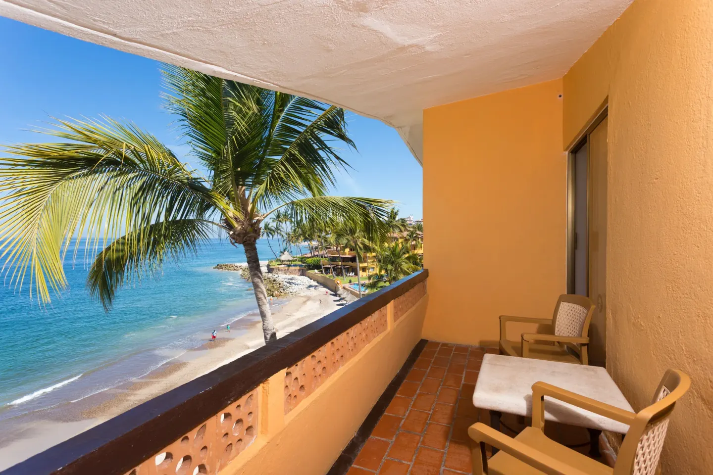 Ocean Front balcony with chairs overlooking beach and palms at Las Palmas by the Sea.
