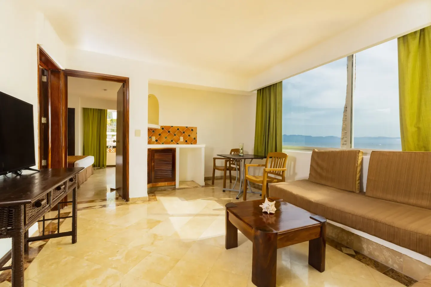 Ocean Front sitting area with sofa and large sea-view window at Las Palmas by the Sea.