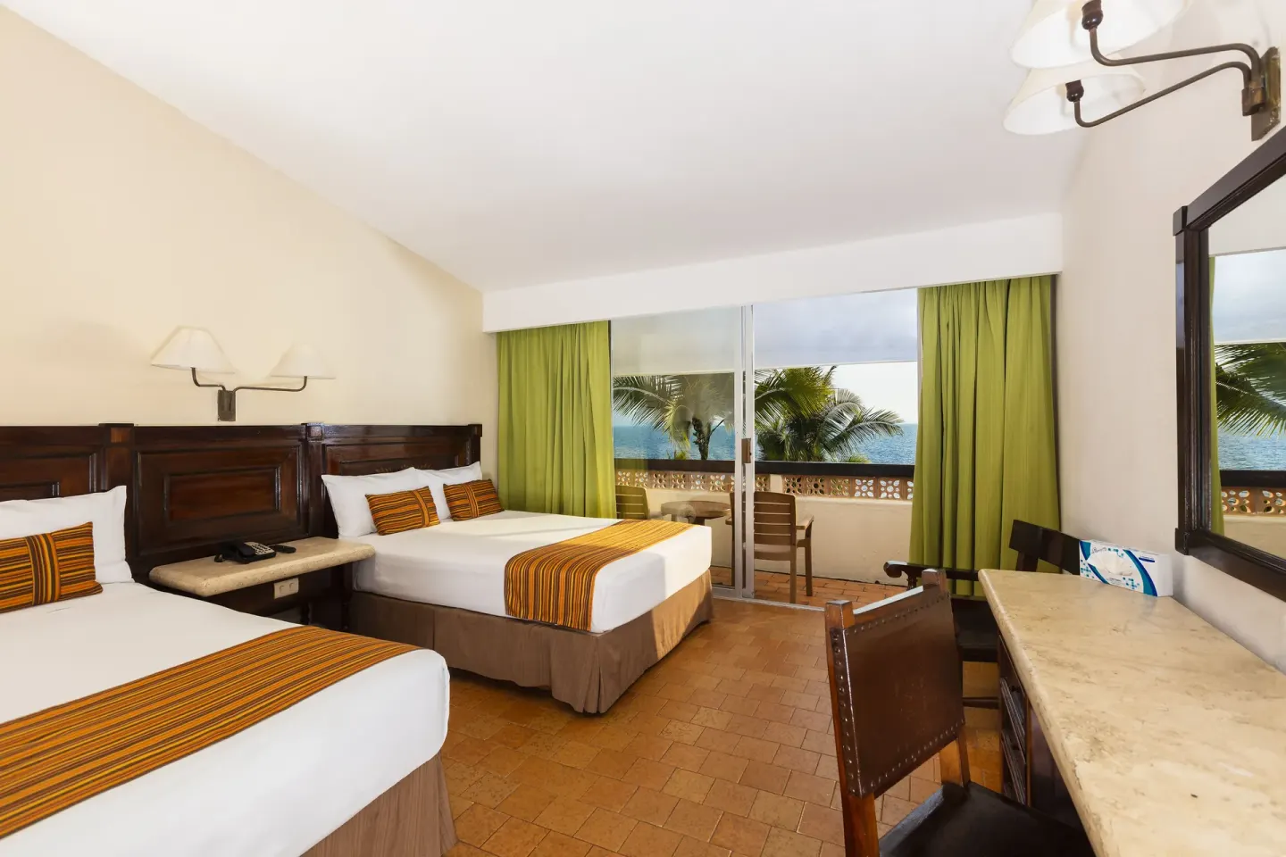 Ocean View Room with two beds, desk and balcony overlooking palms and sea at Las Palmas by the Sea.