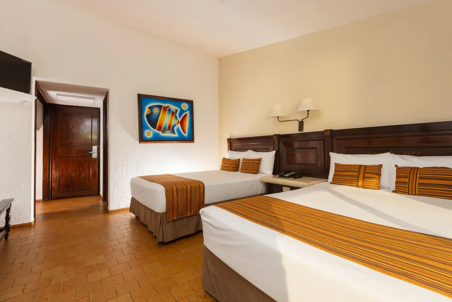 Ocean View Room with two beds, wall art and entry door at Las Palmas by the Sea.