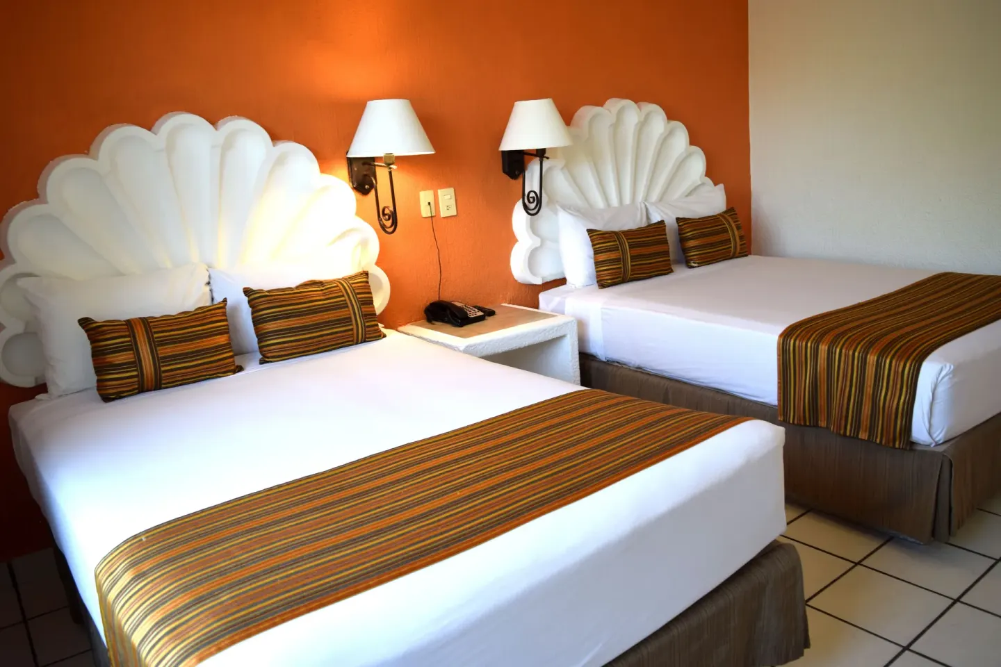Standard room with two double beds and shell headboards at Las Palmas by the Sea.