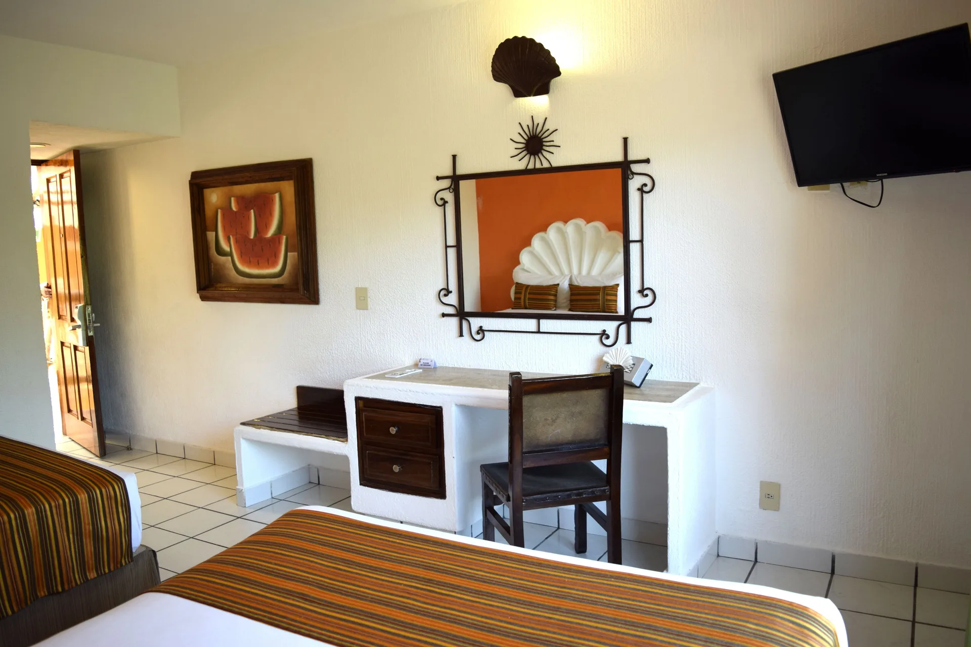 Standard Room with two beds, desk, mirror, and wall-mounted TV at Las Palmas by the Sea.