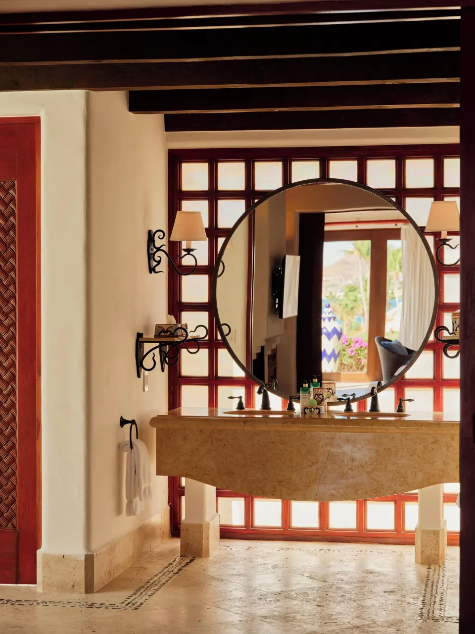 Bathroom vanity with round mirror and marble counter at Las Ventanas al Paraiso.