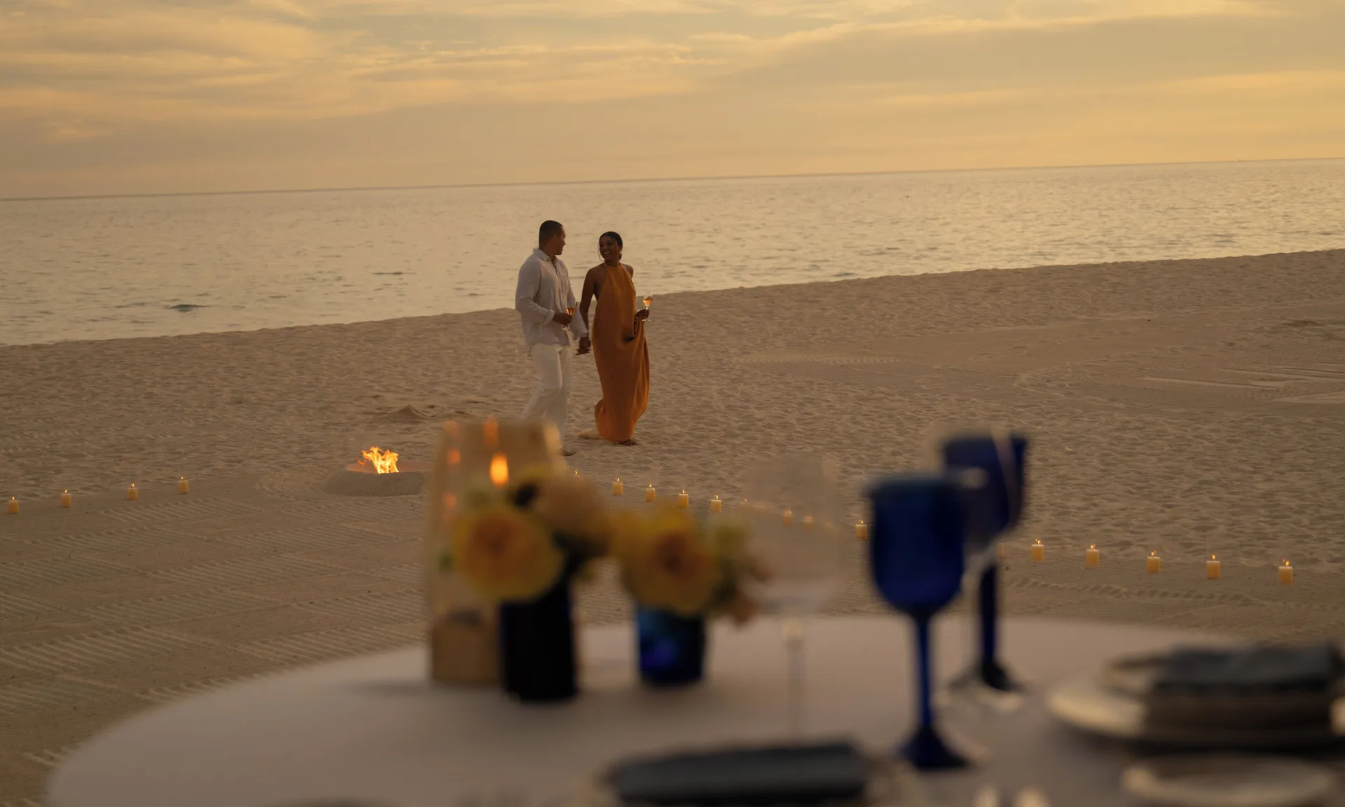 Couple walks along a candlelit beach at sunset at Las Ventanas al Paraiso.