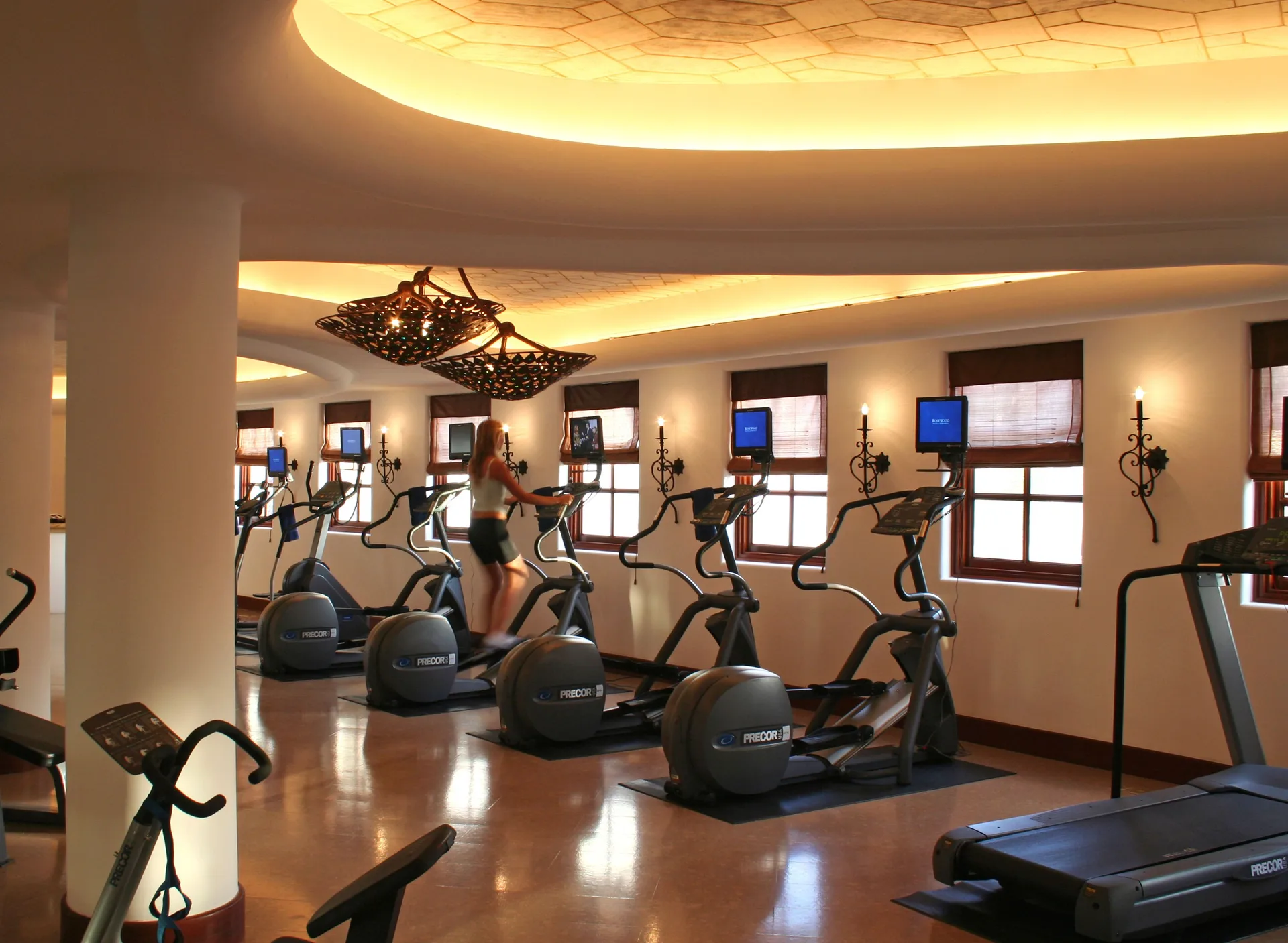 Cardio machines lined beneath warm ceiling lights at Las Ventanas al Paraiso.