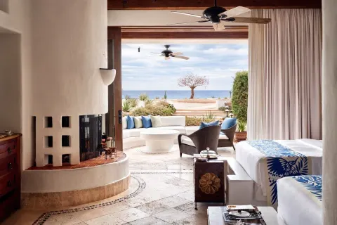 Guest room with two beds, fireplace, and terrace ocean view at Las Ventanas al Paraiso.