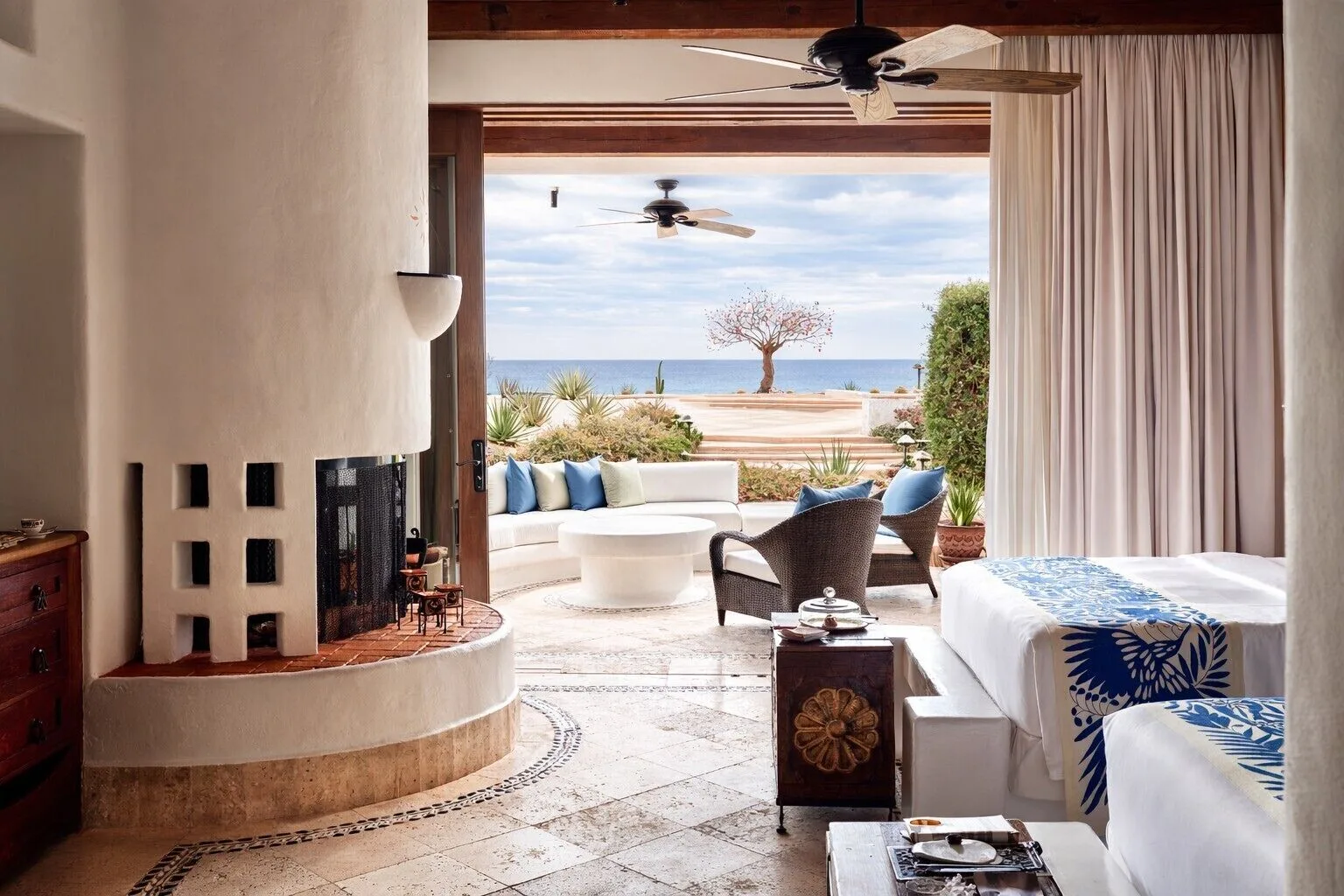 Guest room with two beds, fireplace, and terrace ocean view at Las Ventanas al Paraiso.