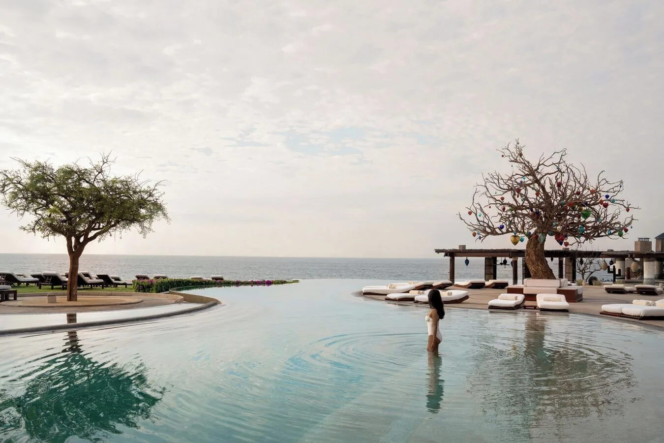 Guest wading in an infinity pool facing the ocean at Las Ventanas al Paraiso.