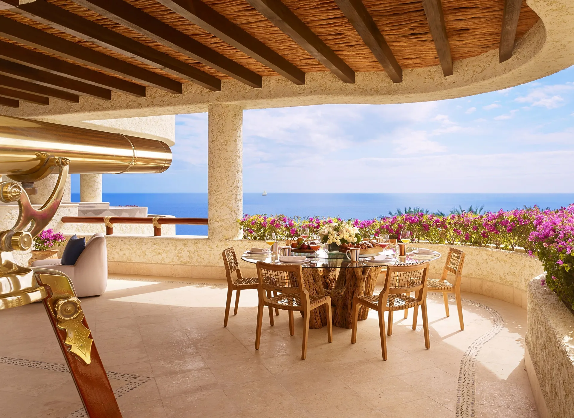 Terrace dining table and brass telescope facing the ocean at Las Ventanas al Paraiso.
