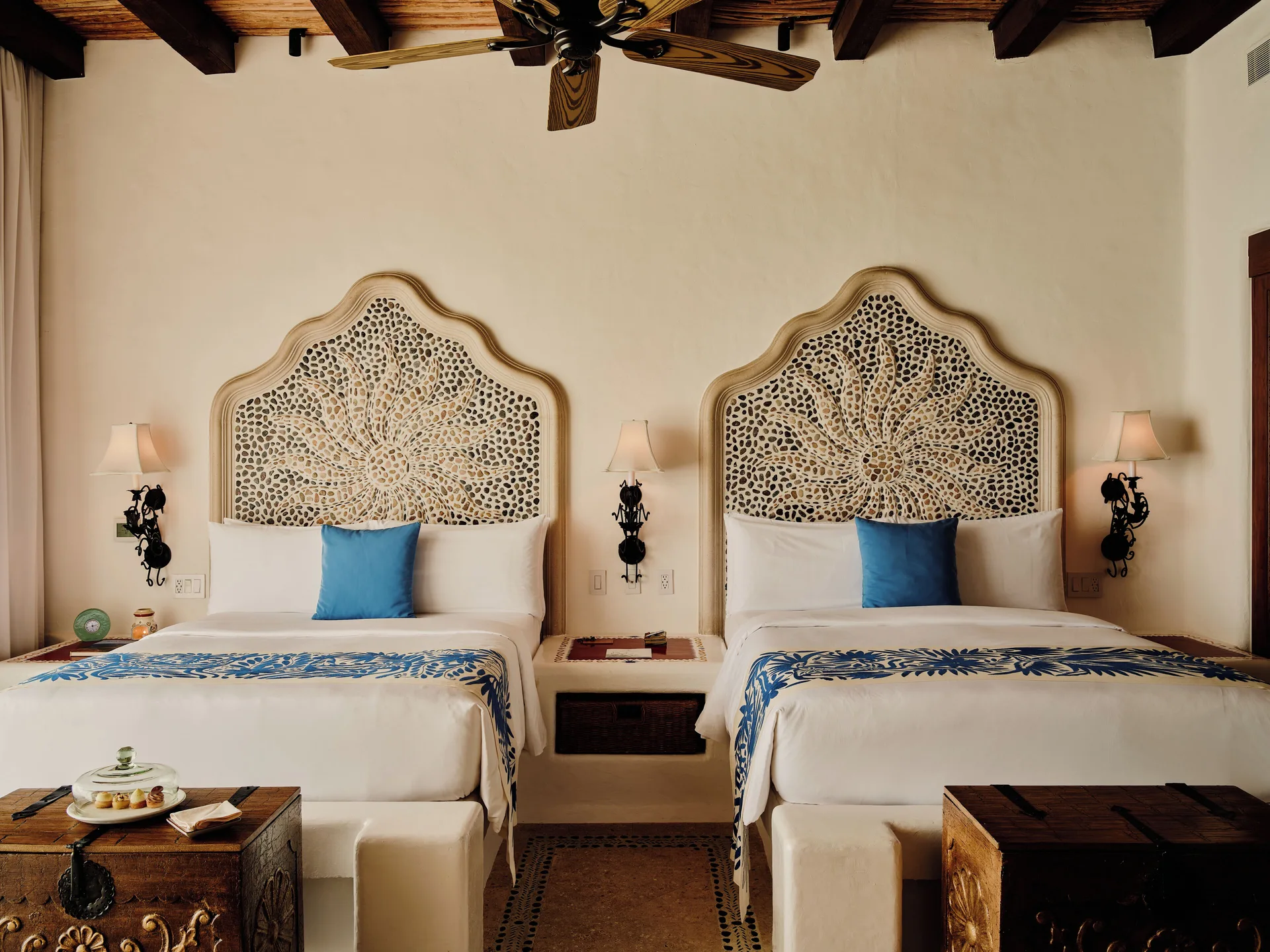 Two beds with carved headboards in an ocean front junior suite at Las Ventanas al Paraiso.