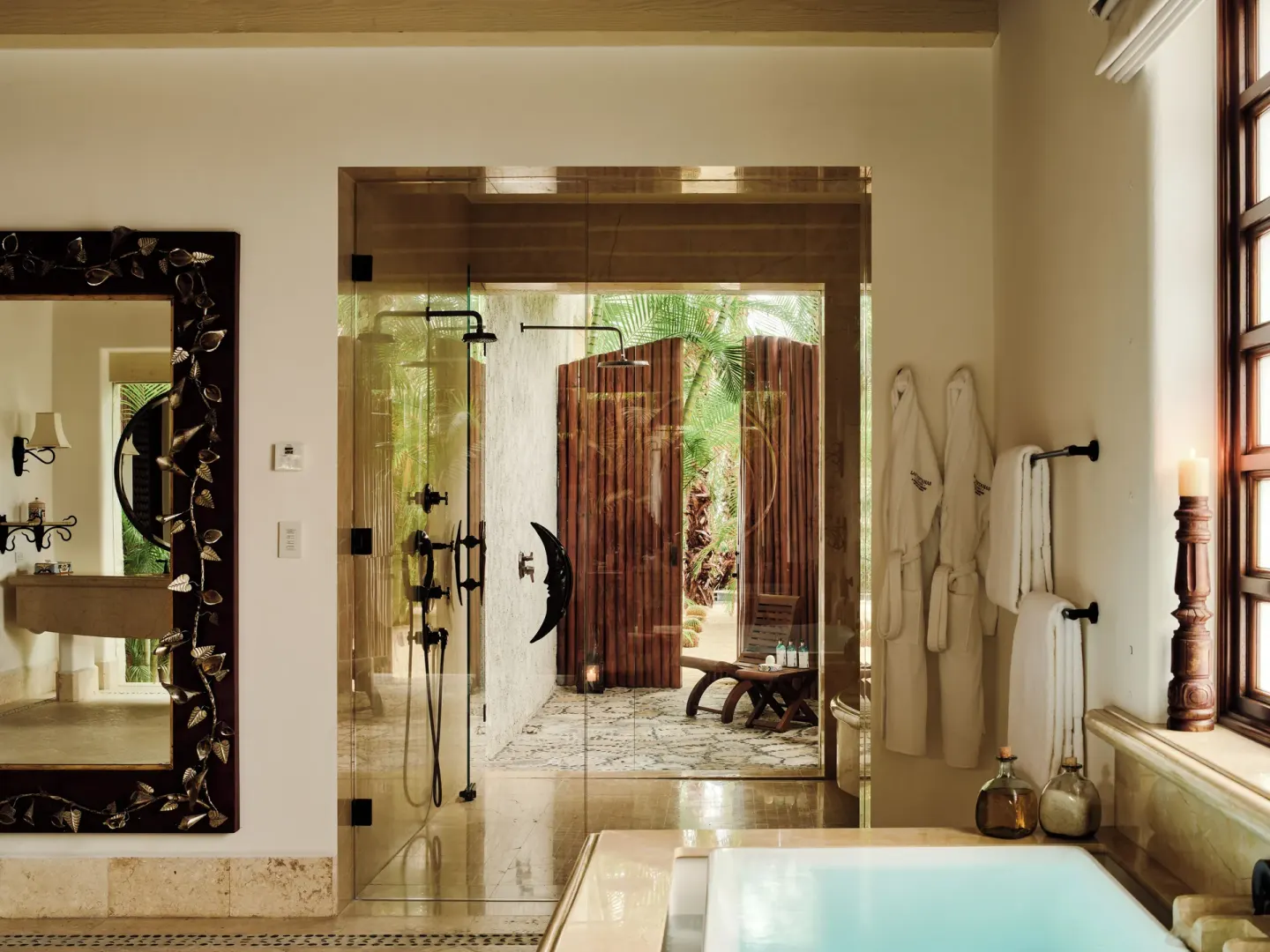 Villa bathroom with soaking tub, glass shower, robes, and garden beyond at Las Ventanas al Paraiso.