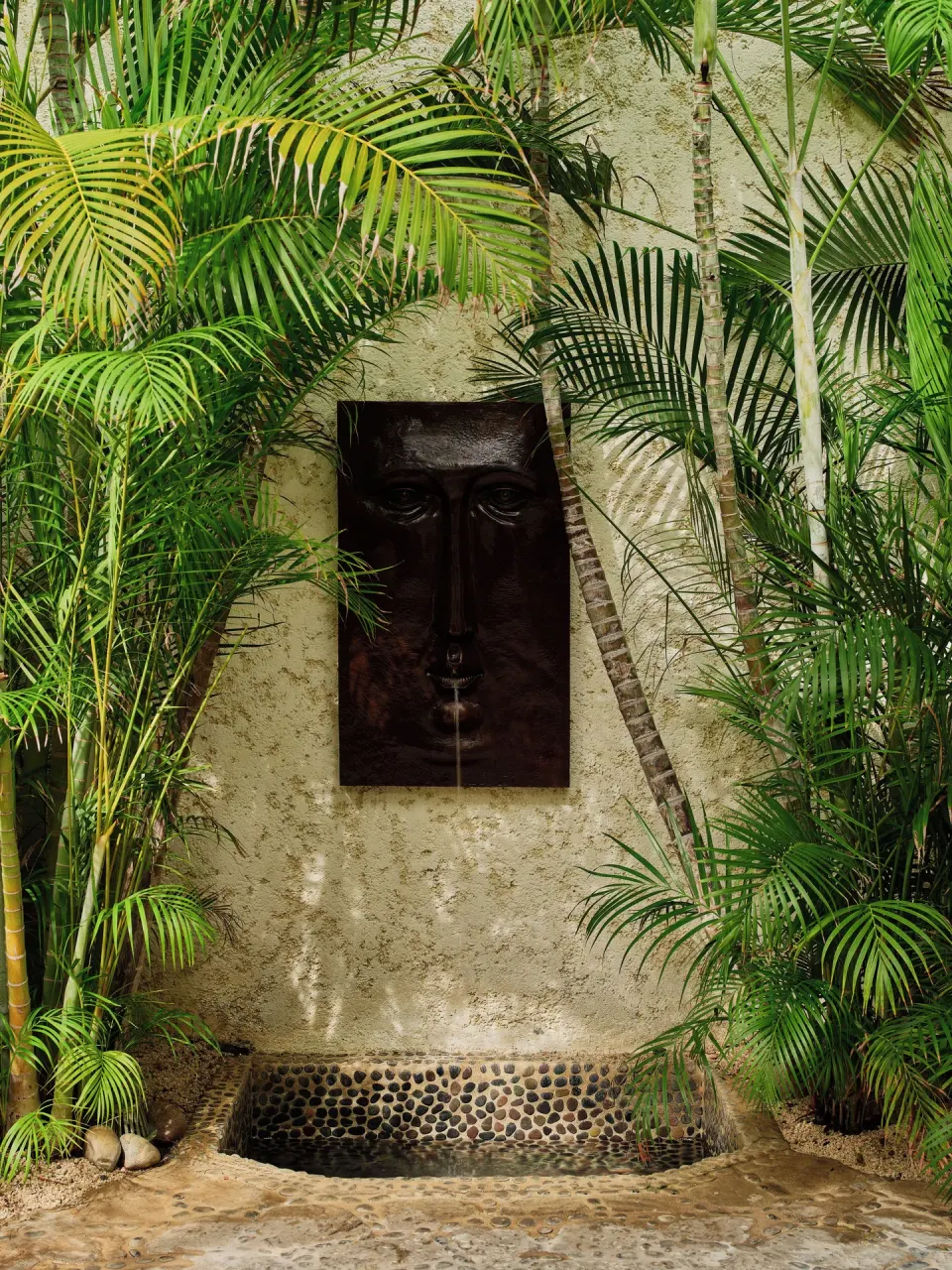 Garden wall fountain with a face sculpture at Las Ventanas al Paraiso.