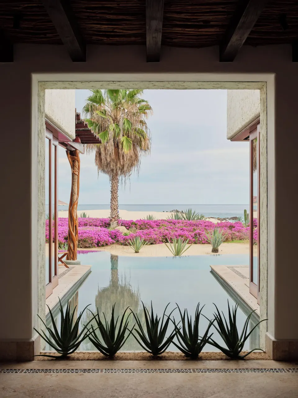 Framed ocean view over a villa pool and flowering garden at Las Ventanas al Paraiso.