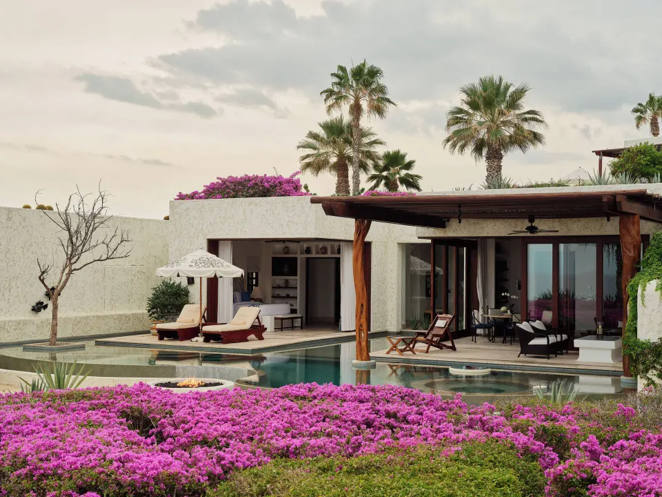 Private villa pool courtyard with palms and pink flowers at Las Ventanas al Paraiso.