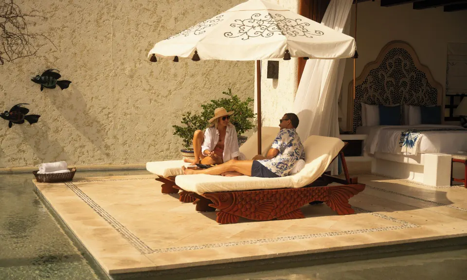 Villa terrace with fish-shaped loungers, umbrella, plunge pool, and bed at Las Ventanas al Paraiso.