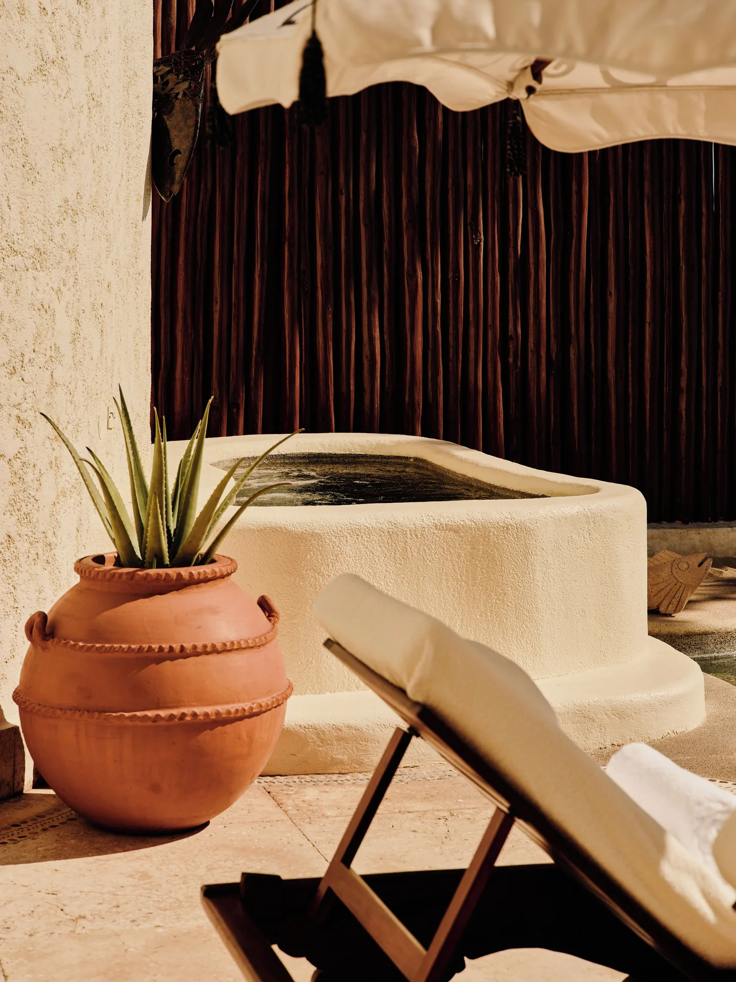 Outdoor soaking tub area of a One Bedroom Oceanfront Villa at Las Ventanas al Paraiso with lounger.