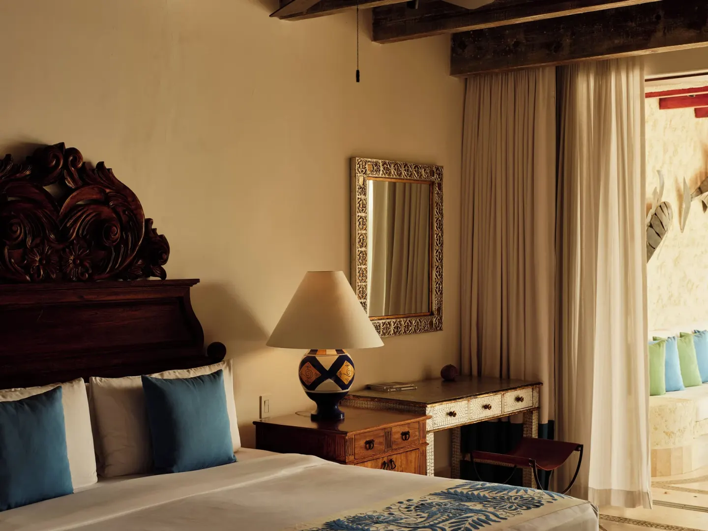 Bedroom in a Three Bedroom Oceanview Suite at Las Ventanas al Paraiso with carved headboard and desk.