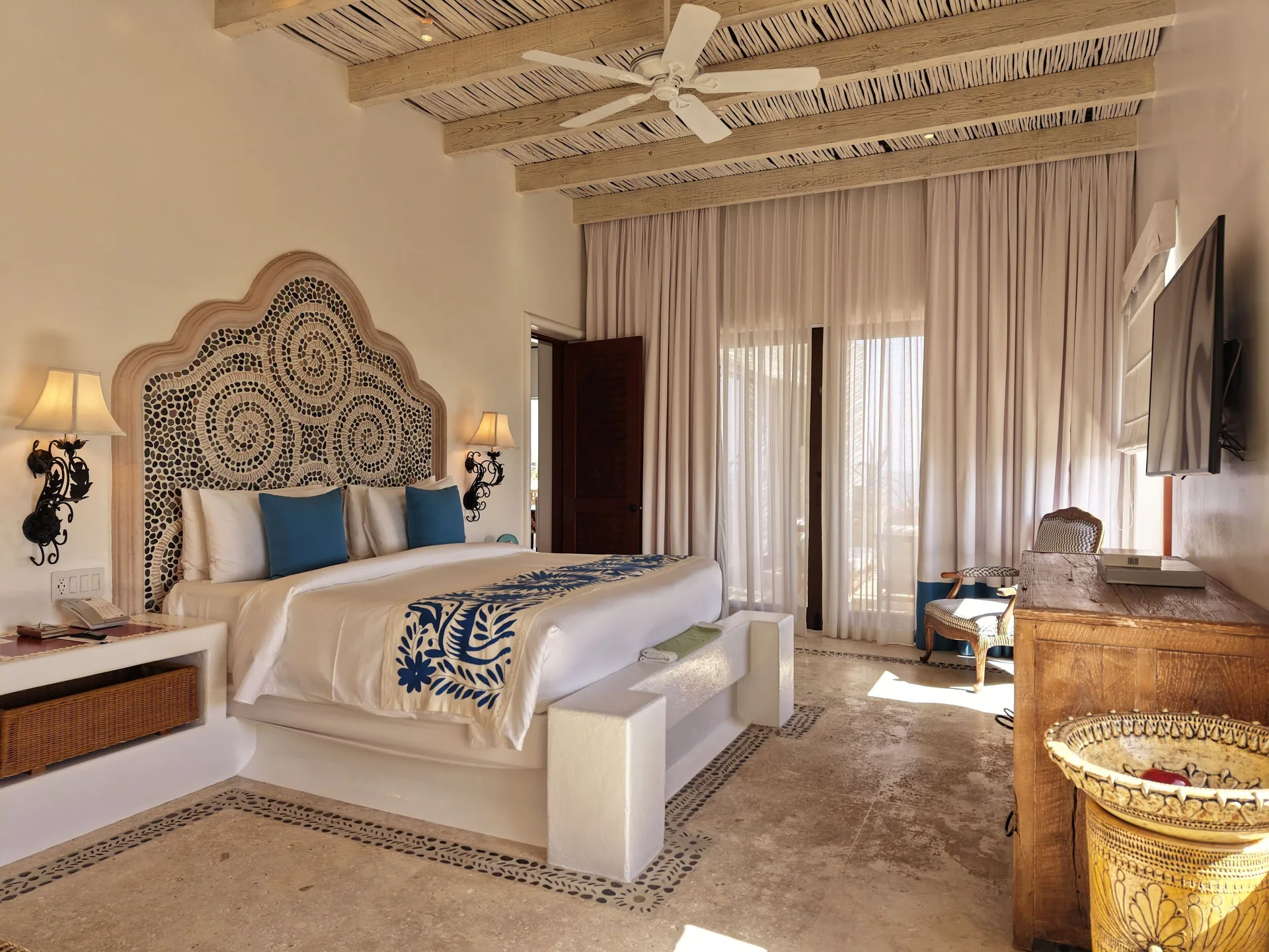 Three Bedroom Oceanview Villa king bedroom at Las Ventanas al Paraiso with carved headboard and TV.